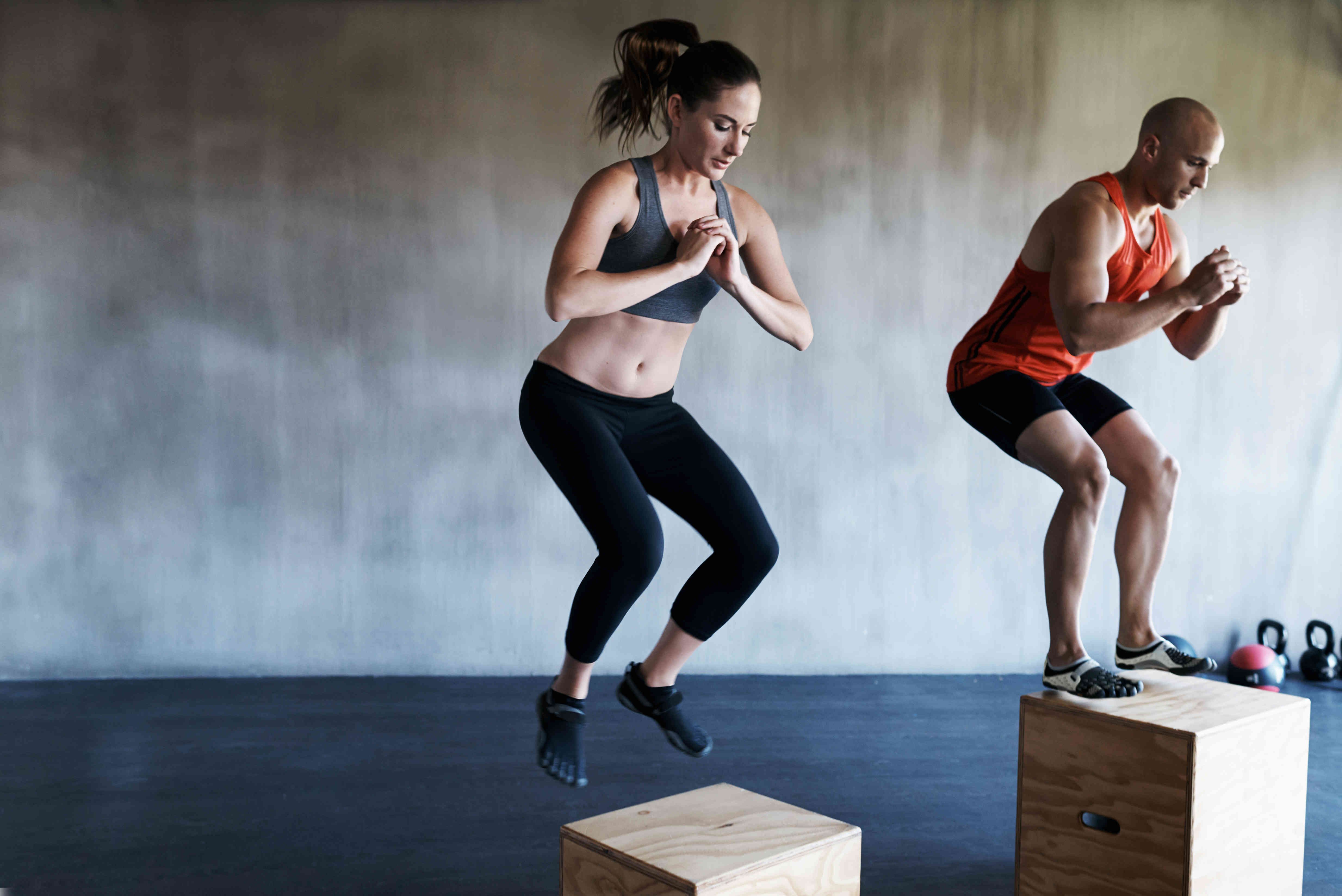 Two people jumping on boxes and train.